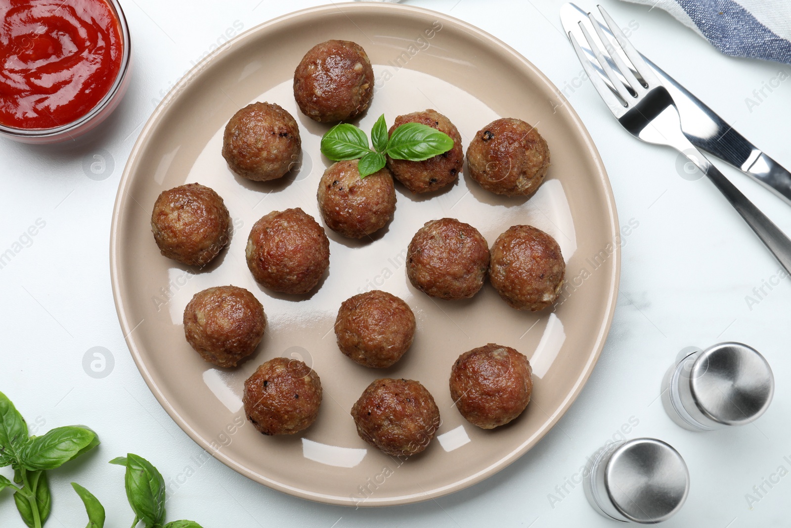 Photo of Tasty cooked meatballs with basil served on white table, flat lay