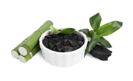 Photo of Fresh bamboo and charcoal on white background