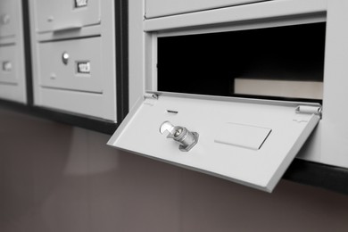 Photo of Open empty metal mailbox with keyhole indoors