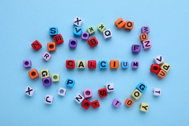 Word Calcium made of colorful plastic beads with letters on turquoise background, top view