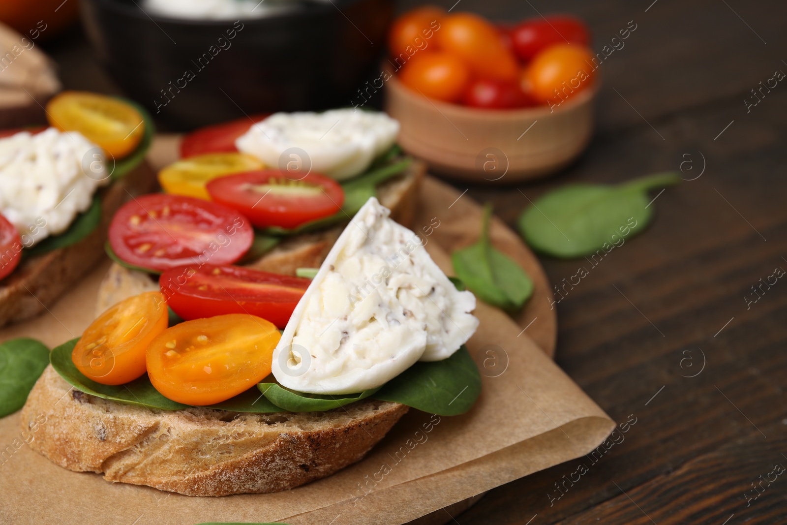 Photo of Delicious sandwiches with burrata cheese and tomatoes on wooden table, closeup. Space for text