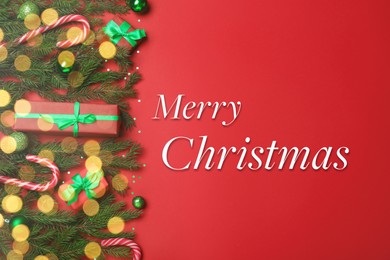 Image of Greeting card with phrase Merry Christmas. Beautiful fir tree branches, gift boxes and festive decor on red background, flat lay. Bokeh effect