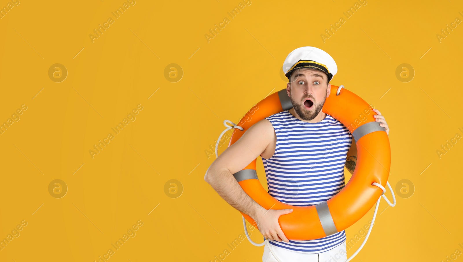 Photo of Emotional sailor with ring buoy on yellow background