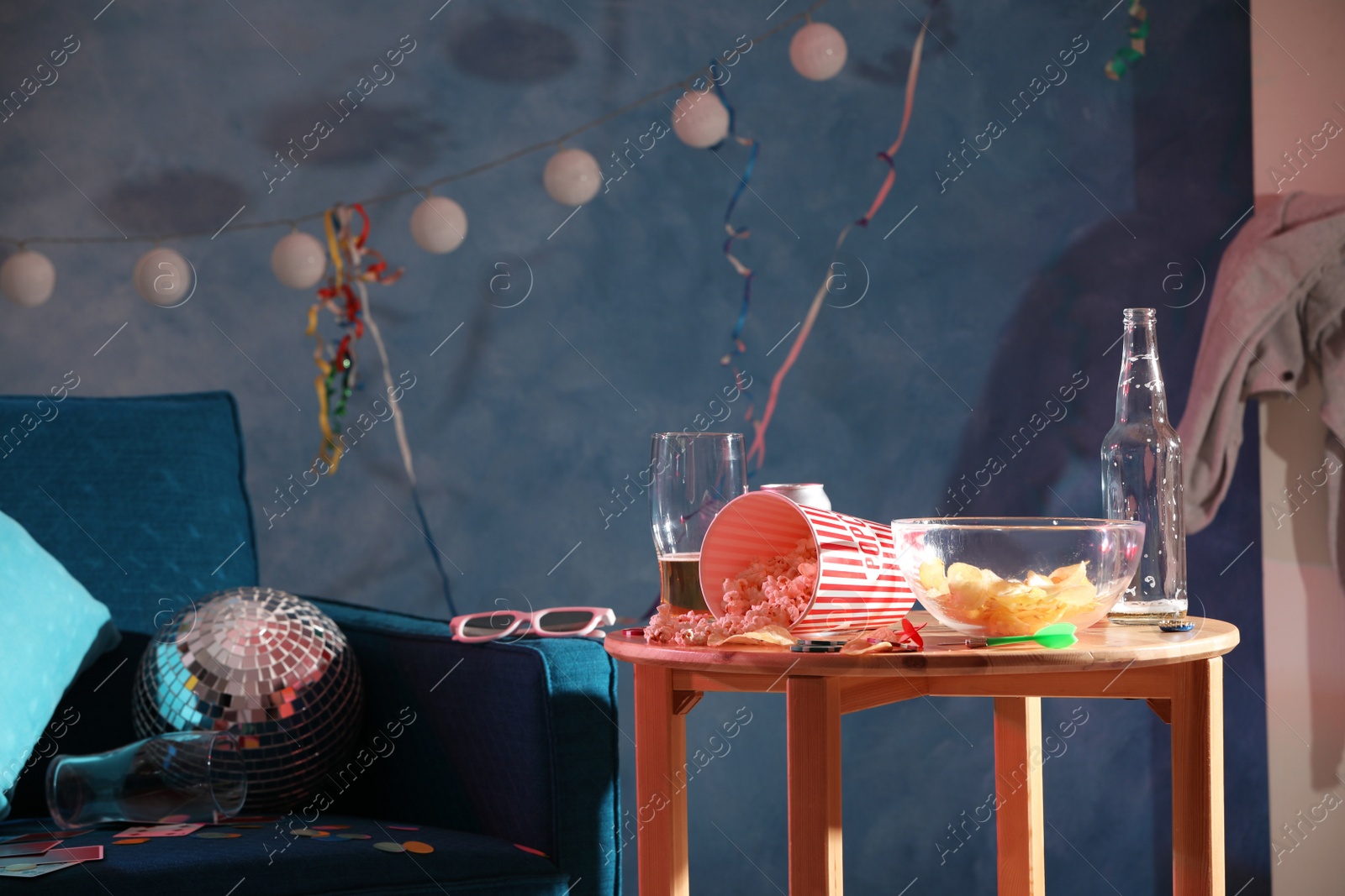 Photo of Wooden table and armchair in messy room after party