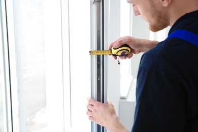 Service man measuring window for installation indoors, closeup