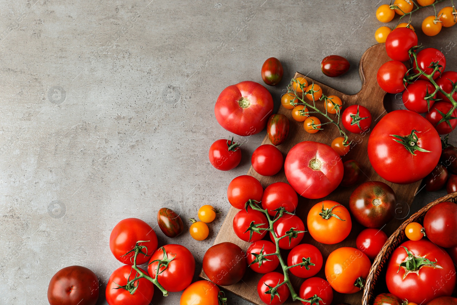 Photo of Flat lay composition with fresh ripe tomatoes on grey table. Space for text