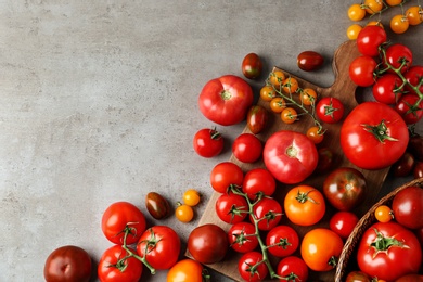 Photo of Flat lay composition with fresh ripe tomatoes on grey table. Space for text