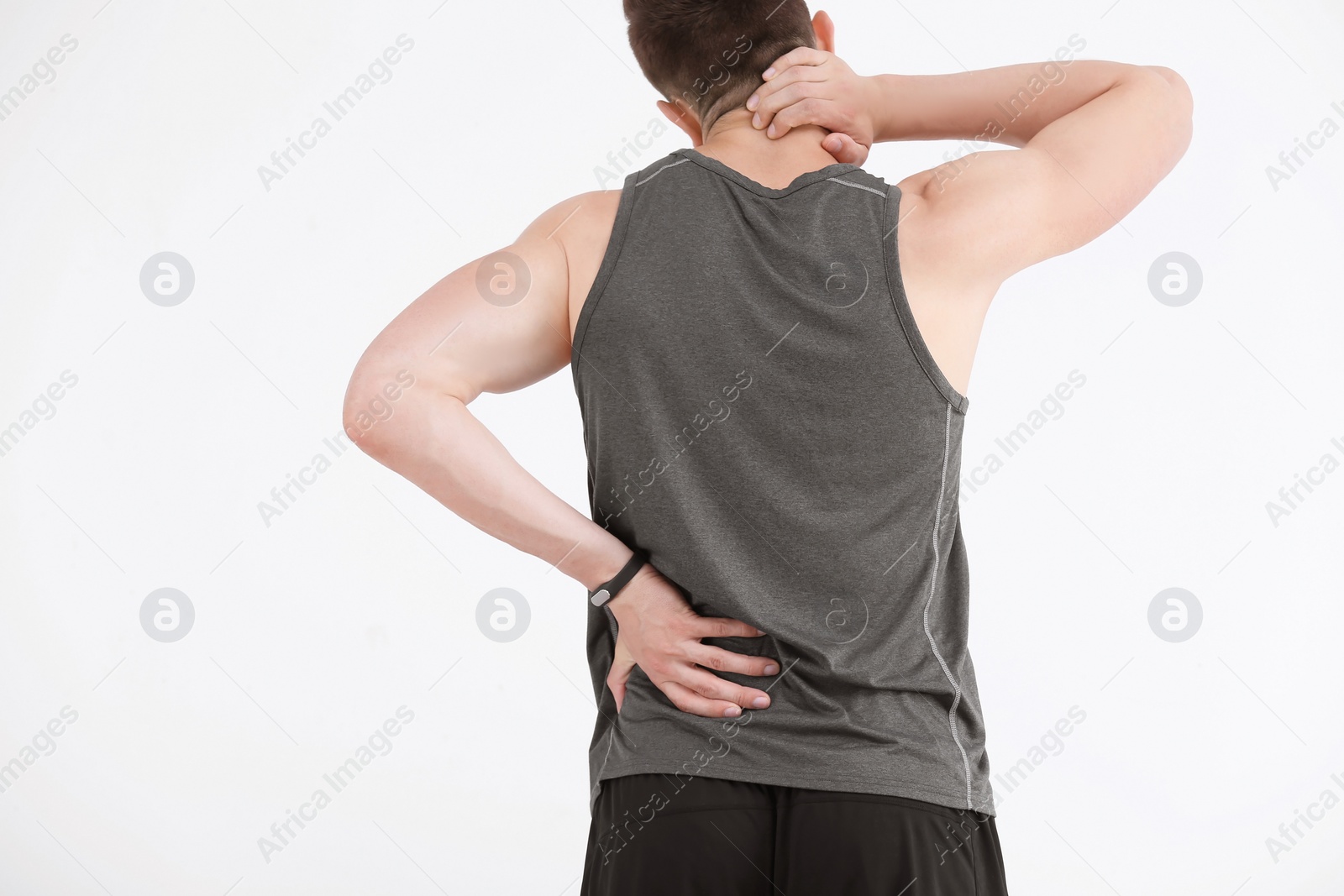 Photo of Man in sportswear suffering from back pain on white background