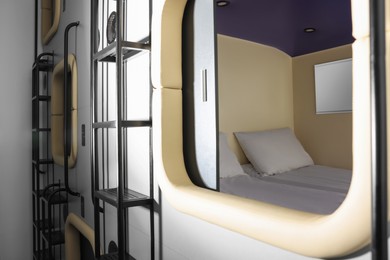 Photo of Capsule with twin bed in modern pod hostel. Stylish interior