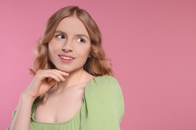 Photo of Portrait of beautiful woman with blonde hair on pink background. Space for text