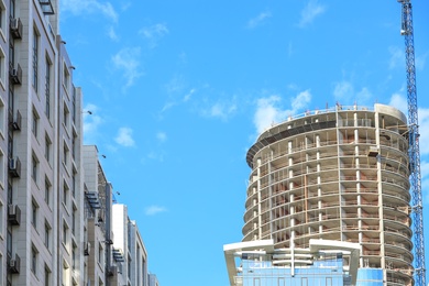 Photo of Unfinished building against blue sky. Construction safety rules