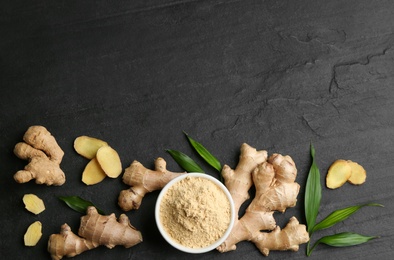 Photo of Flat lay composition with fresh and dry ginger on black slate table. Space for text