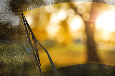 Image of Car windshield wiper cleaning water drops from glass