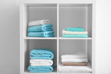 Photo of Clean towels on shelves in bathroom