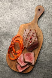 Photo of Delicious grilled beef steak with spices on gray table, top view