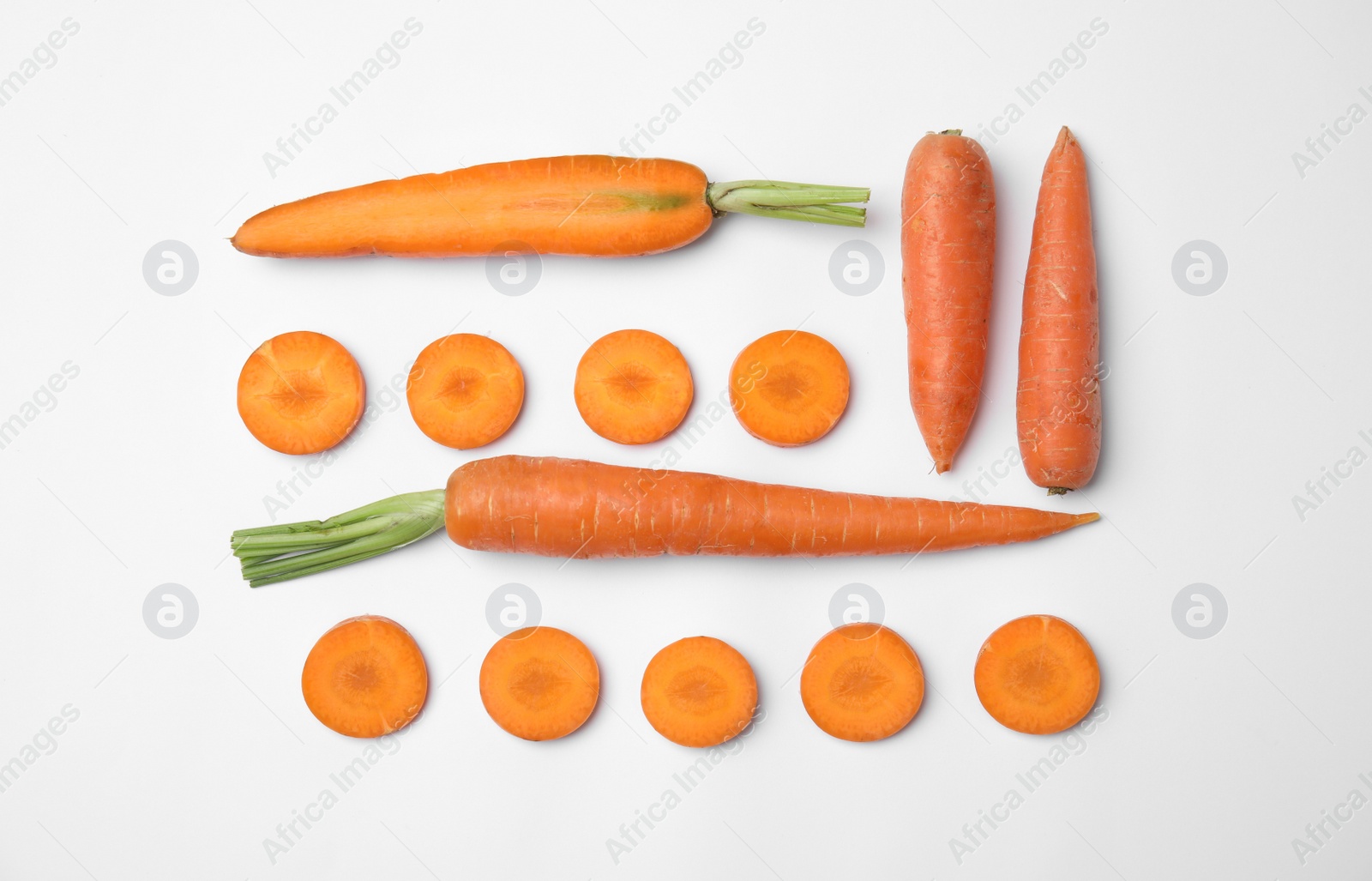 Photo of Whole and cut fresh carrots on white background