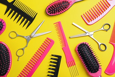 Photo of Flat lay composition with professional scissors and other hairdresser's equipment on yellow background. Haircut tool