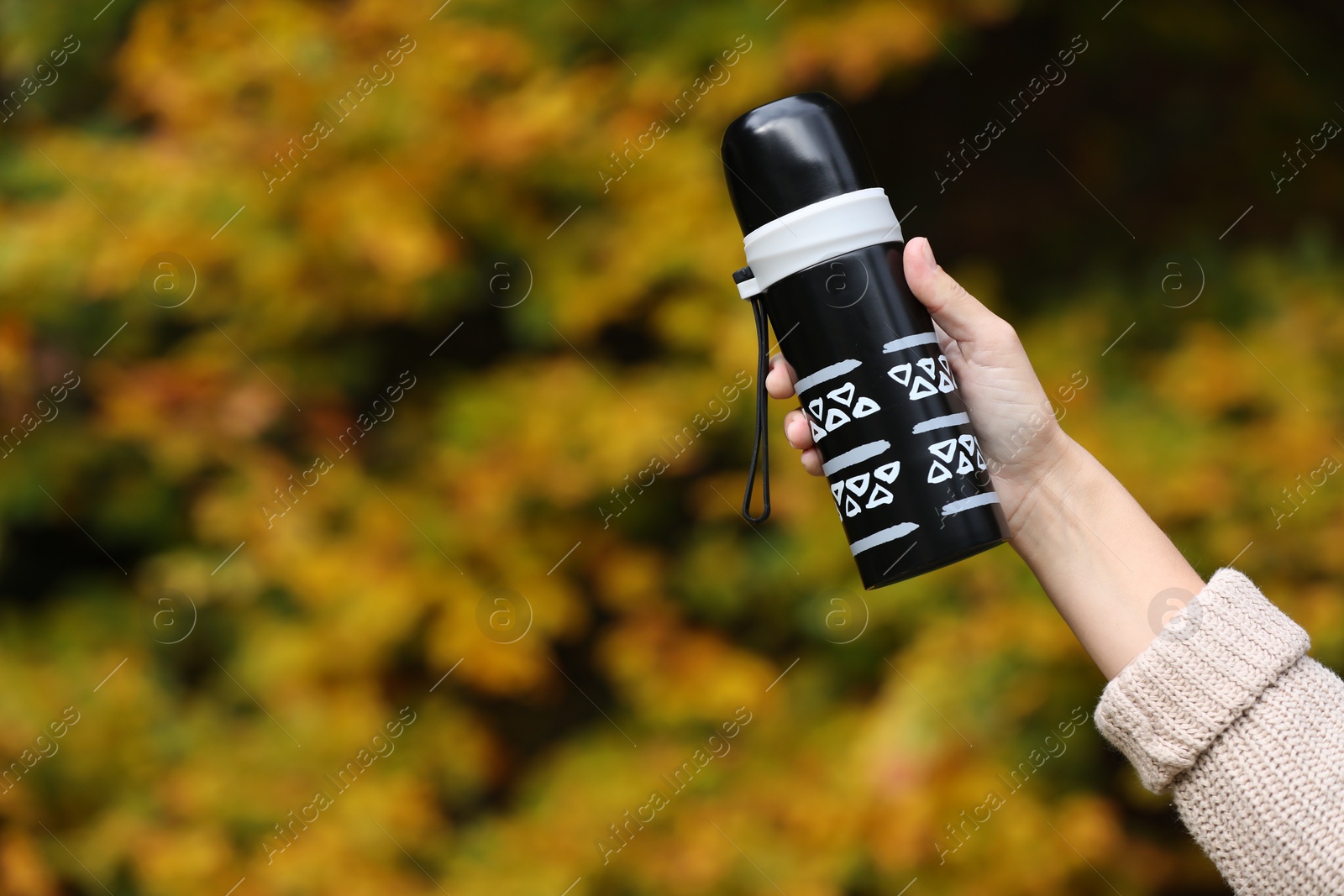 Photo of Woman with thermos outdoors, closeup. Space for text