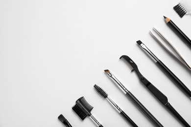 Photo of Set of professional eyebrow tools on white background, flat lay. Space for text