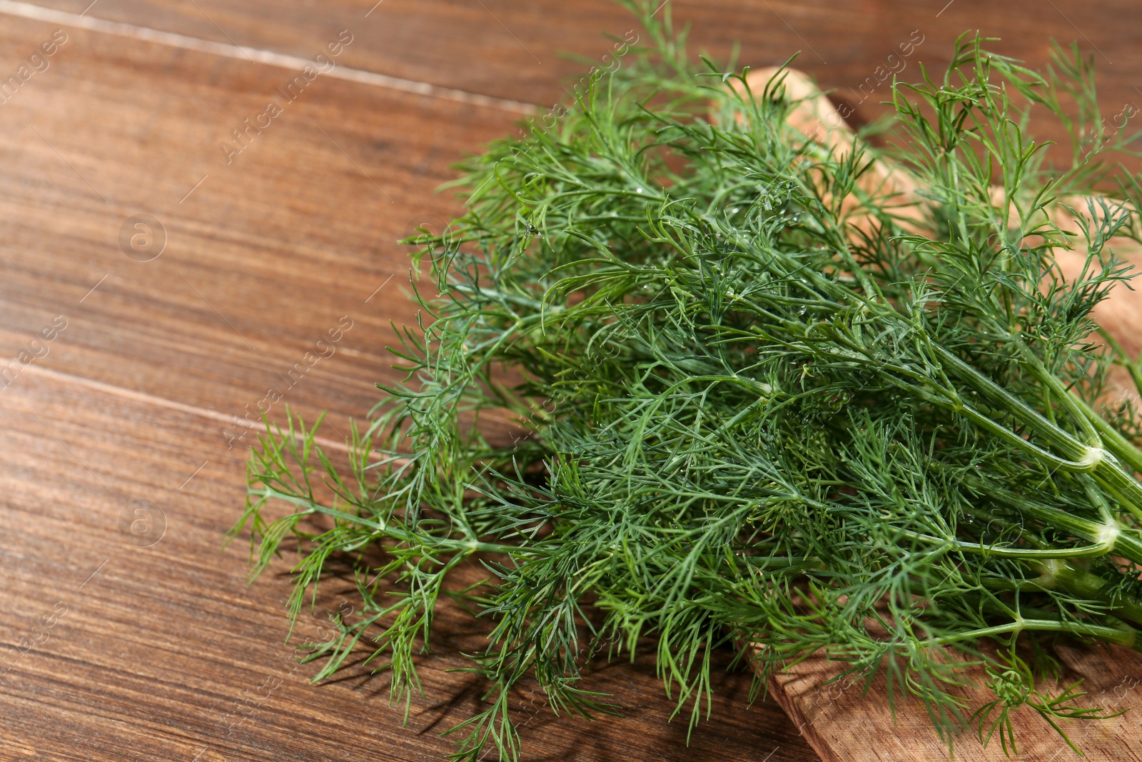 Photo of Fresh green dill on wooden table, closeup. Space for text