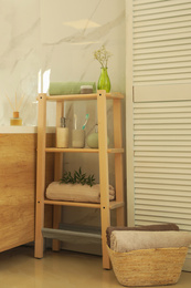 Photo of Shelving unit with toiletries in stylish bathroom interior 