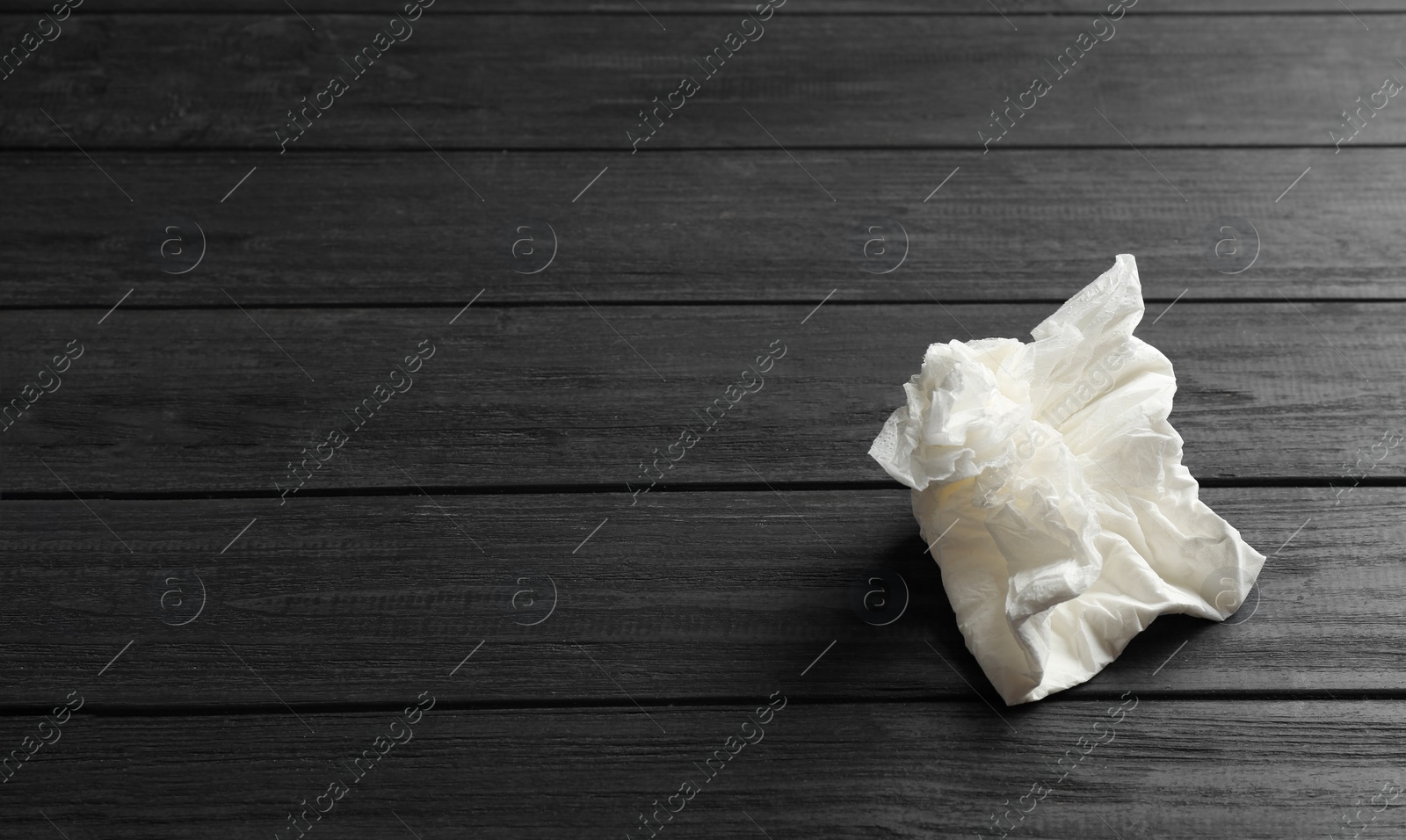 Photo of Crumpled paper napkin and space for text on wooden background