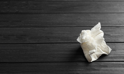 Photo of Crumpled paper napkin and space for text on wooden background