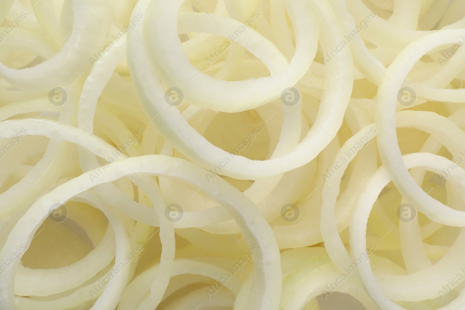 Photo of Fresh ripe onion rings as background, top view