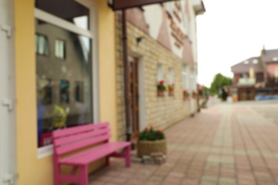 Photo of Blurred view of pink bench near modern store