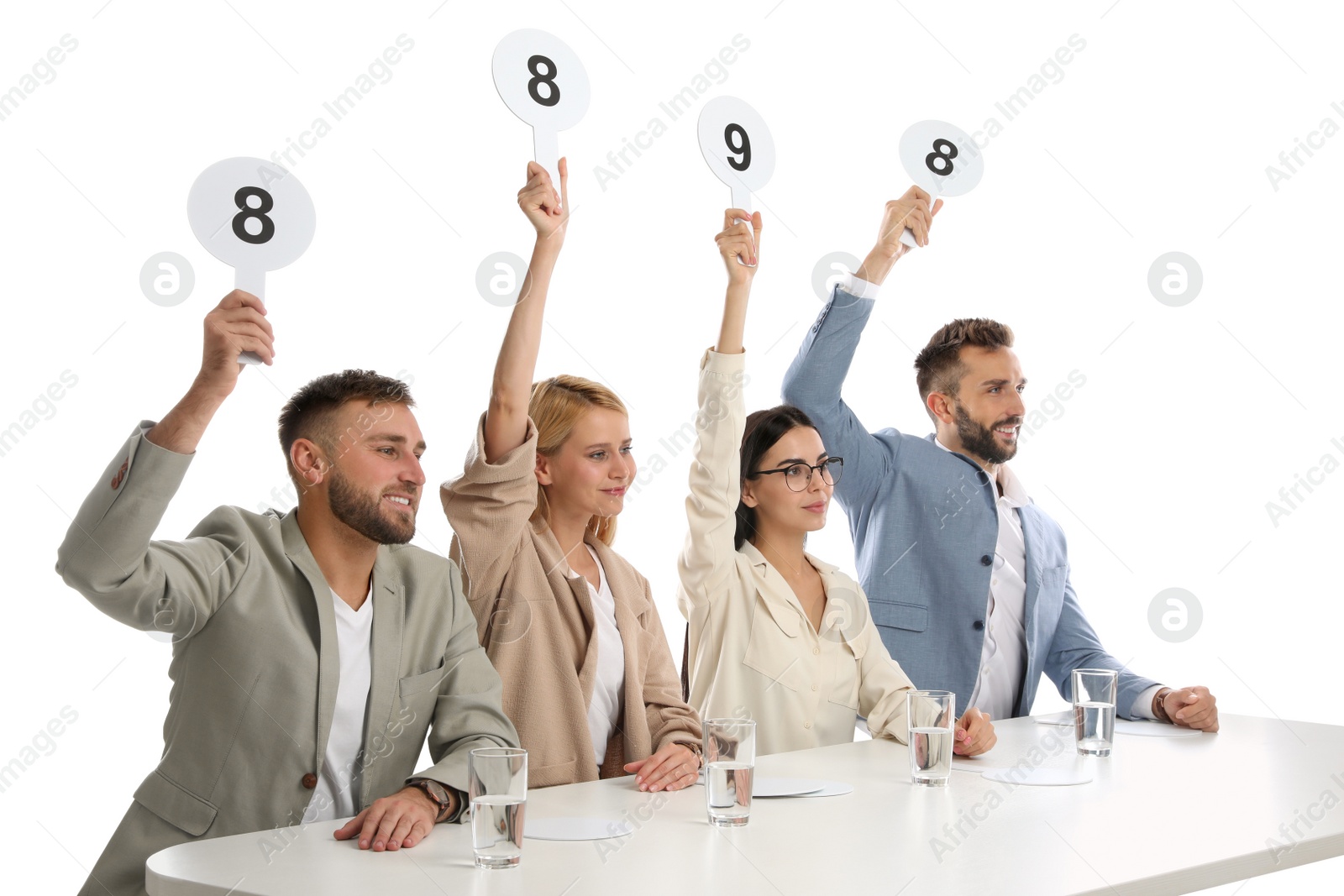 Photo of Panel of judges holding different score signs at table on white background