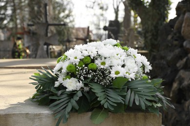 Photo of Funeral wreath of flowers on tombstone in cemetery