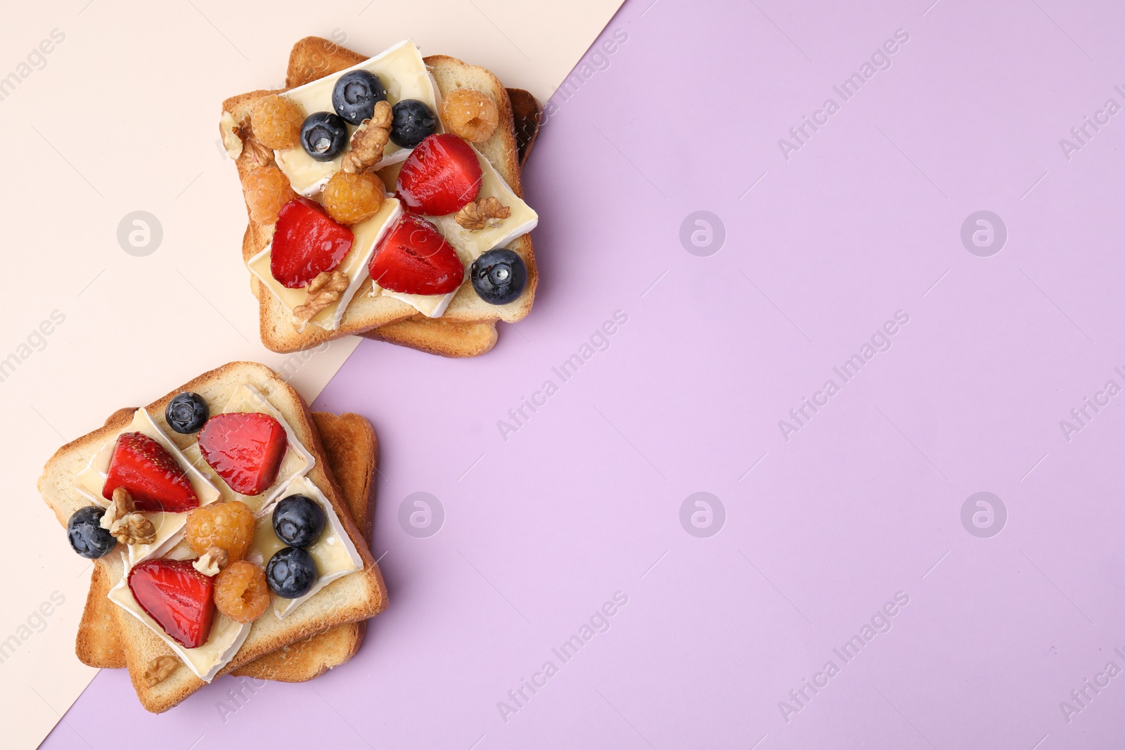 Photo of Tasty sandwiches with brie cheese, fresh berries and walnuts on color background, flat lay. Space for text