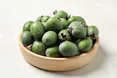 Fresh green feijoa fruits in bowl on light table