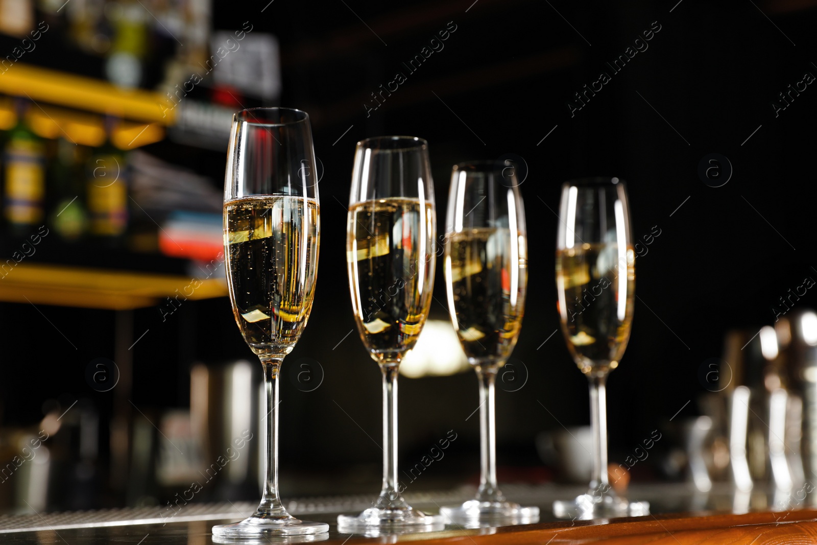 Photo of Glasses of champagne on counter in bar. Space for text