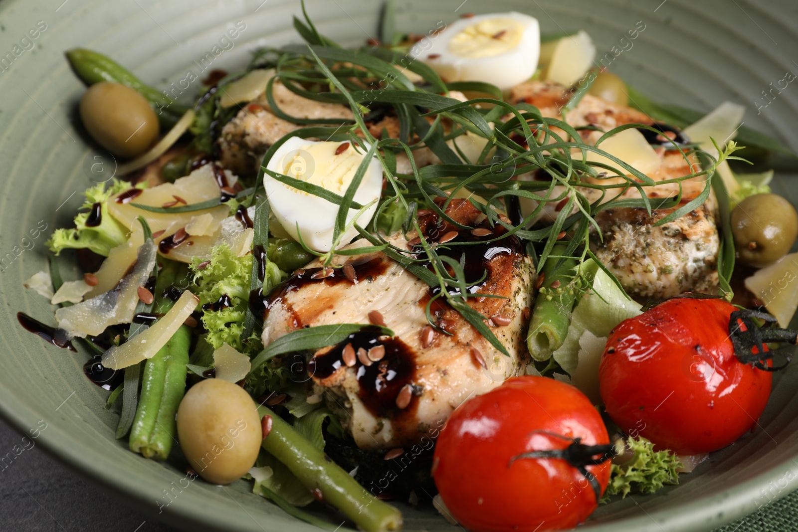 Photo of Tasty chicken, boiled egg and vegetables with tarragon in olive plate, closeup