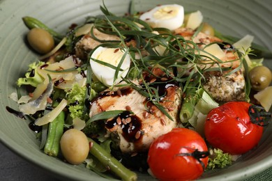 Tasty chicken, boiled egg and vegetables with tarragon in olive plate, closeup