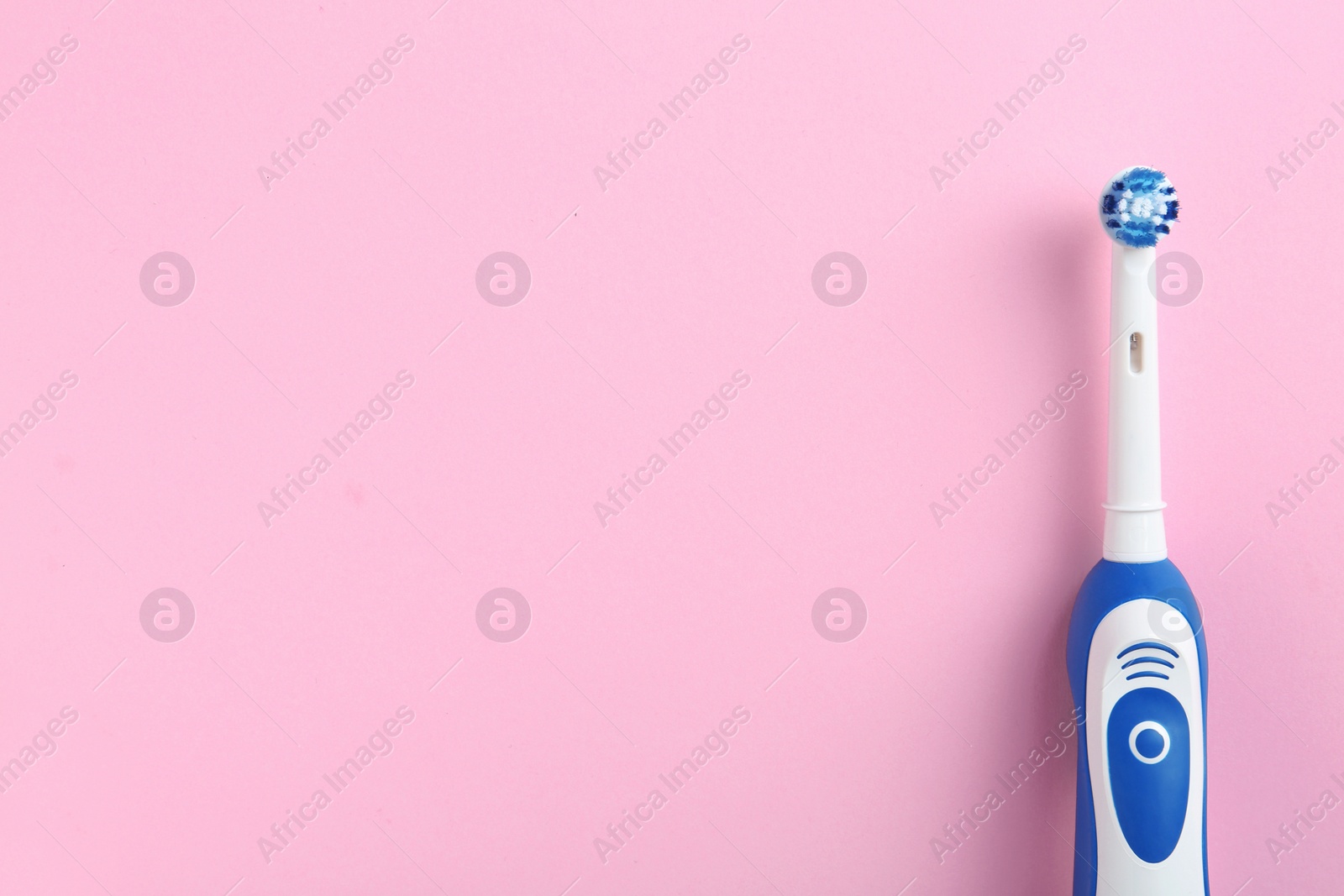 Photo of Electric toothbrush and space for text on color background, top view