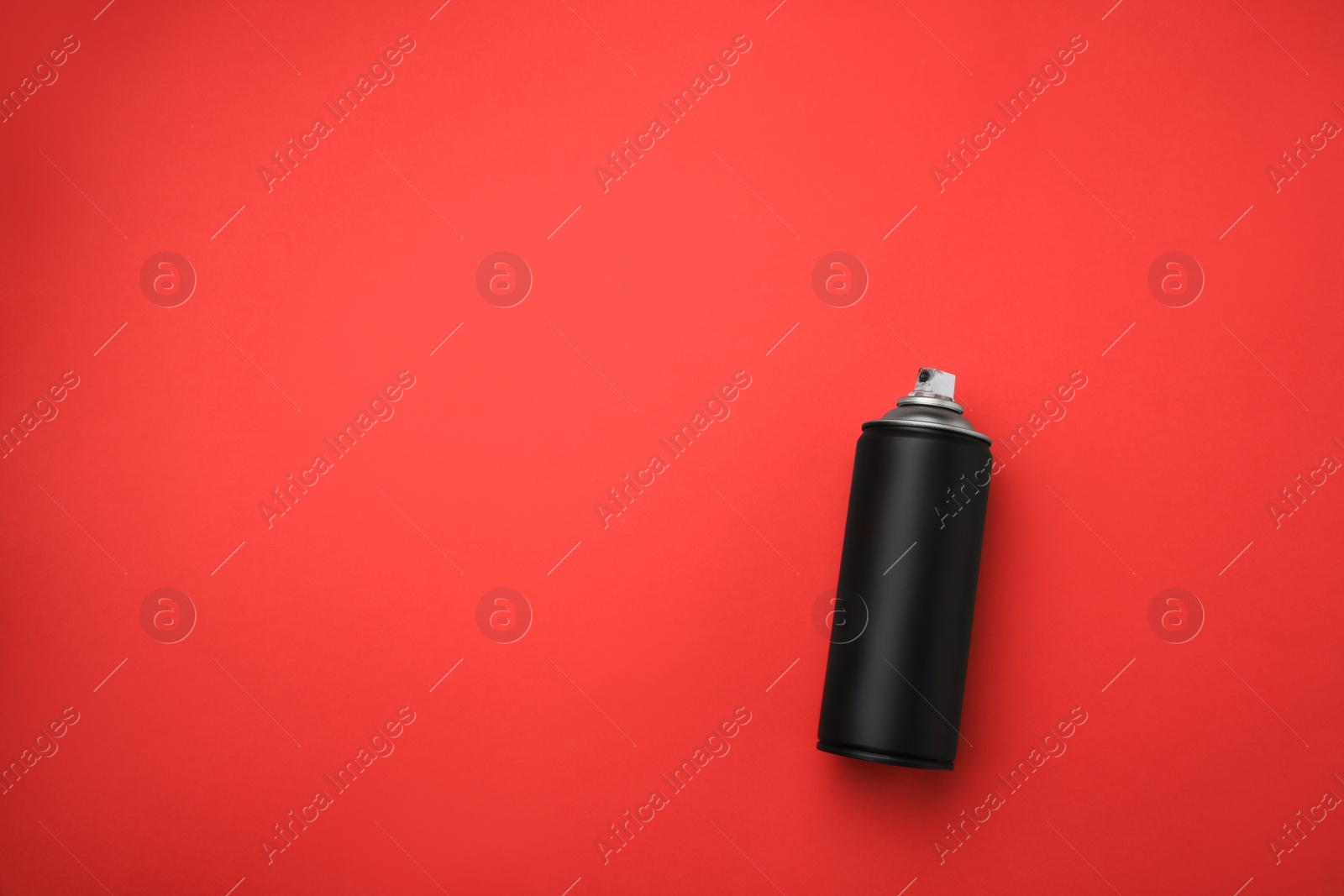 Photo of Can of black graffiti spray paint on red background, top view. Space for text