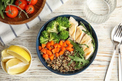 Photo of Ceramic bowl with quinoa and garnish on table, top view