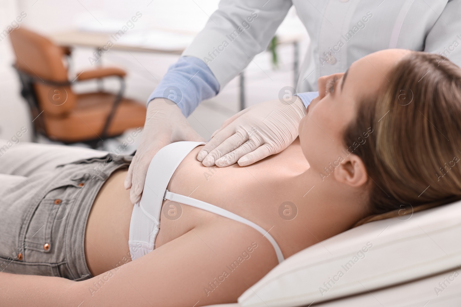 Photo of Mammologist checking young woman's breast in hospital