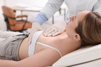 Mammologist checking young woman's breast in hospital