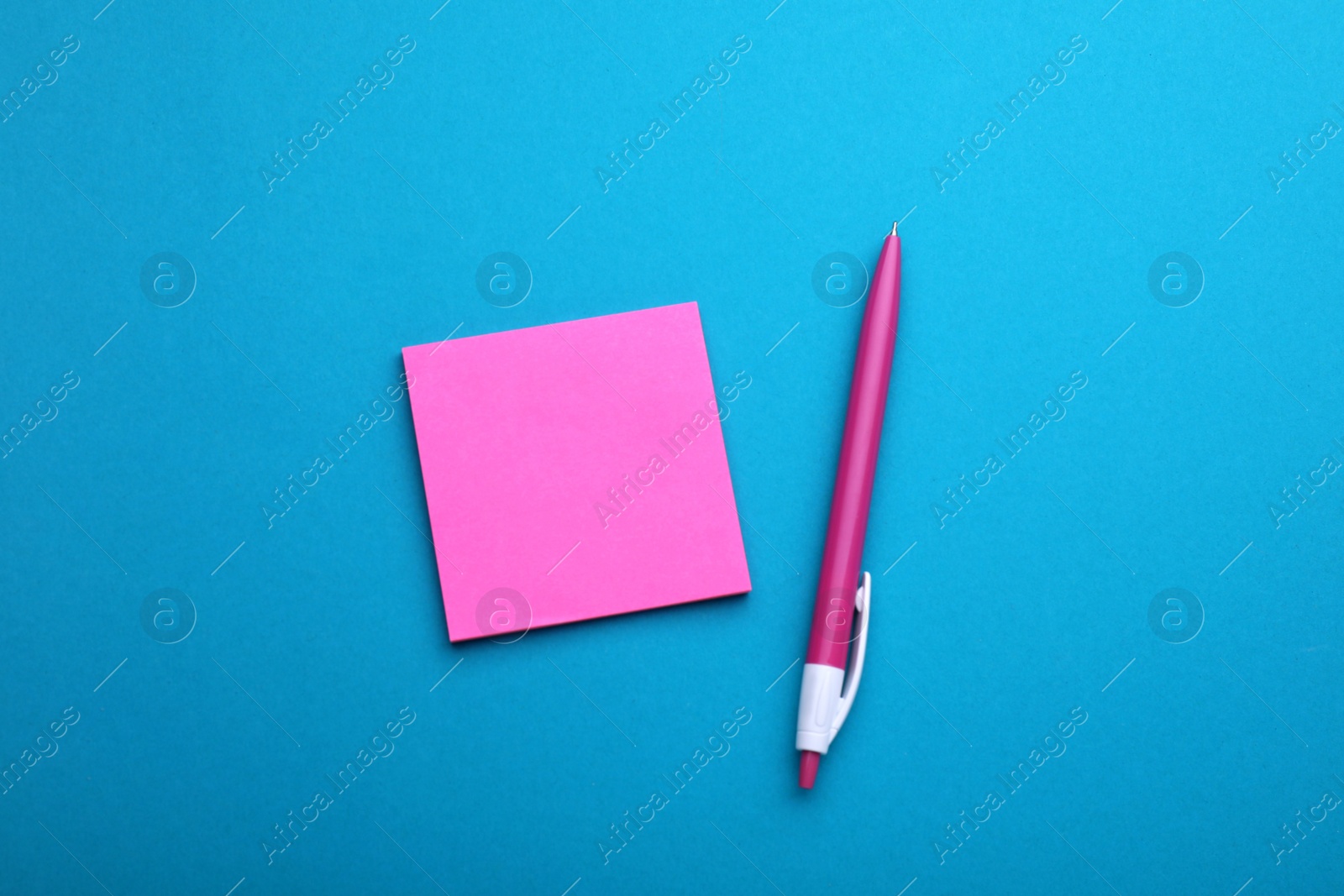 Photo of Paper note and pen on blue background, flat lay