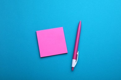Photo of Paper note and pen on blue background, flat lay