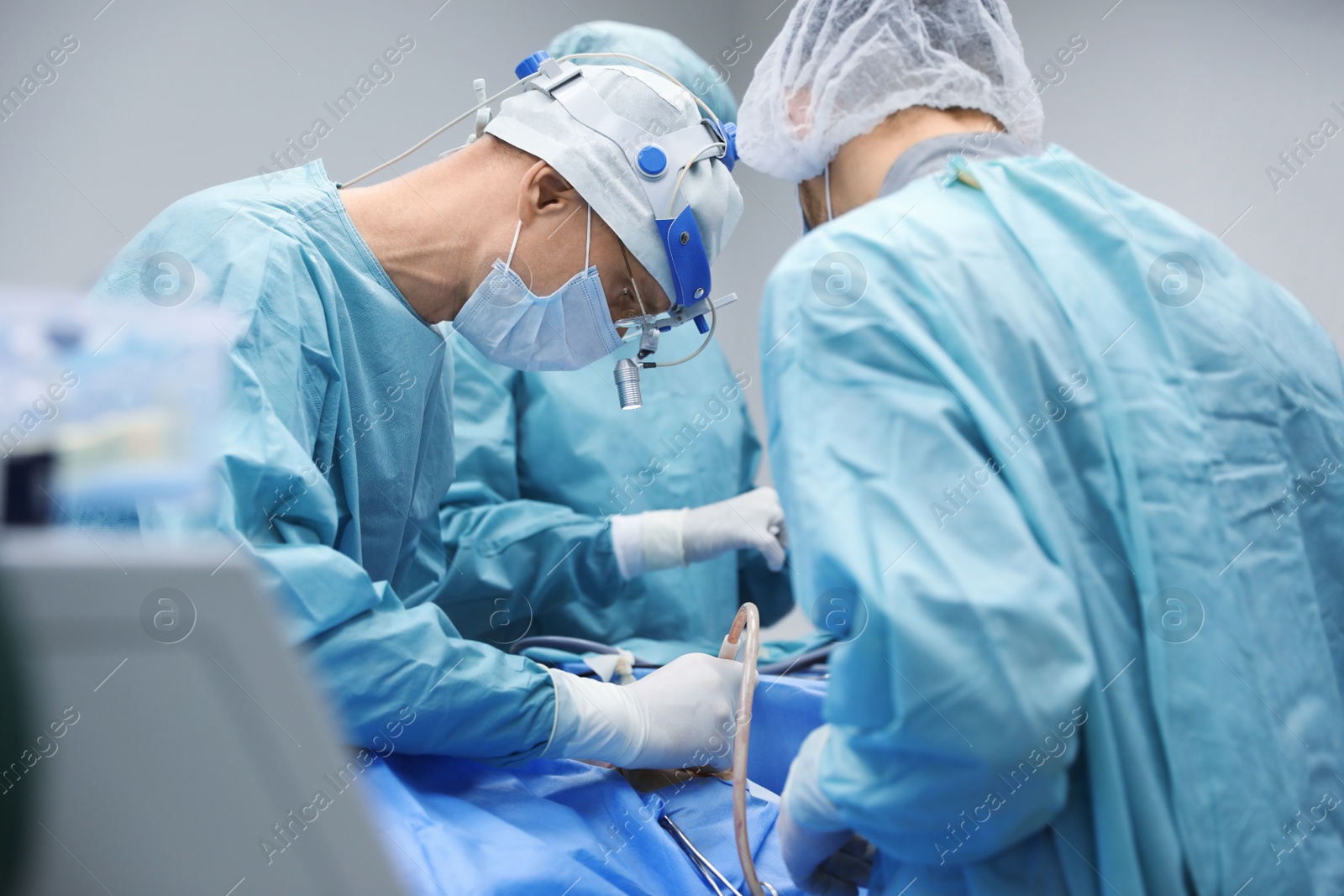 Photo of Professional doctors performing 
frontal sinus trephination in surgery room