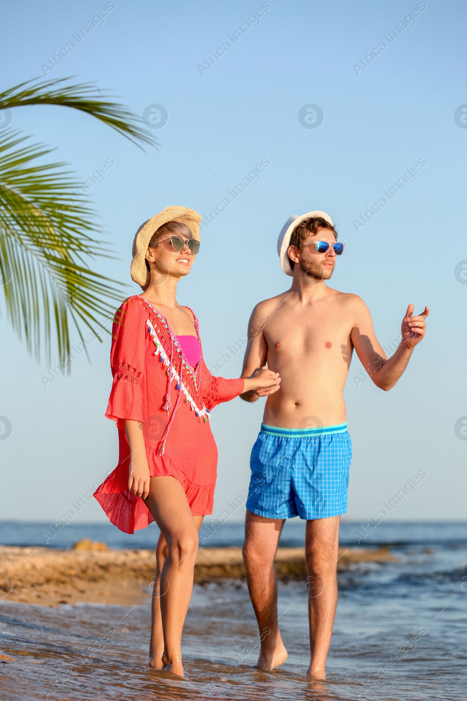 Photo of Happy young couple walking together on beach