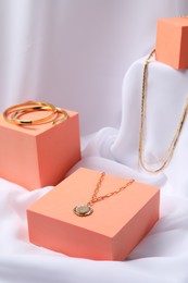 Photo of Stylish presentation of bracelets and necklaces on white cloth