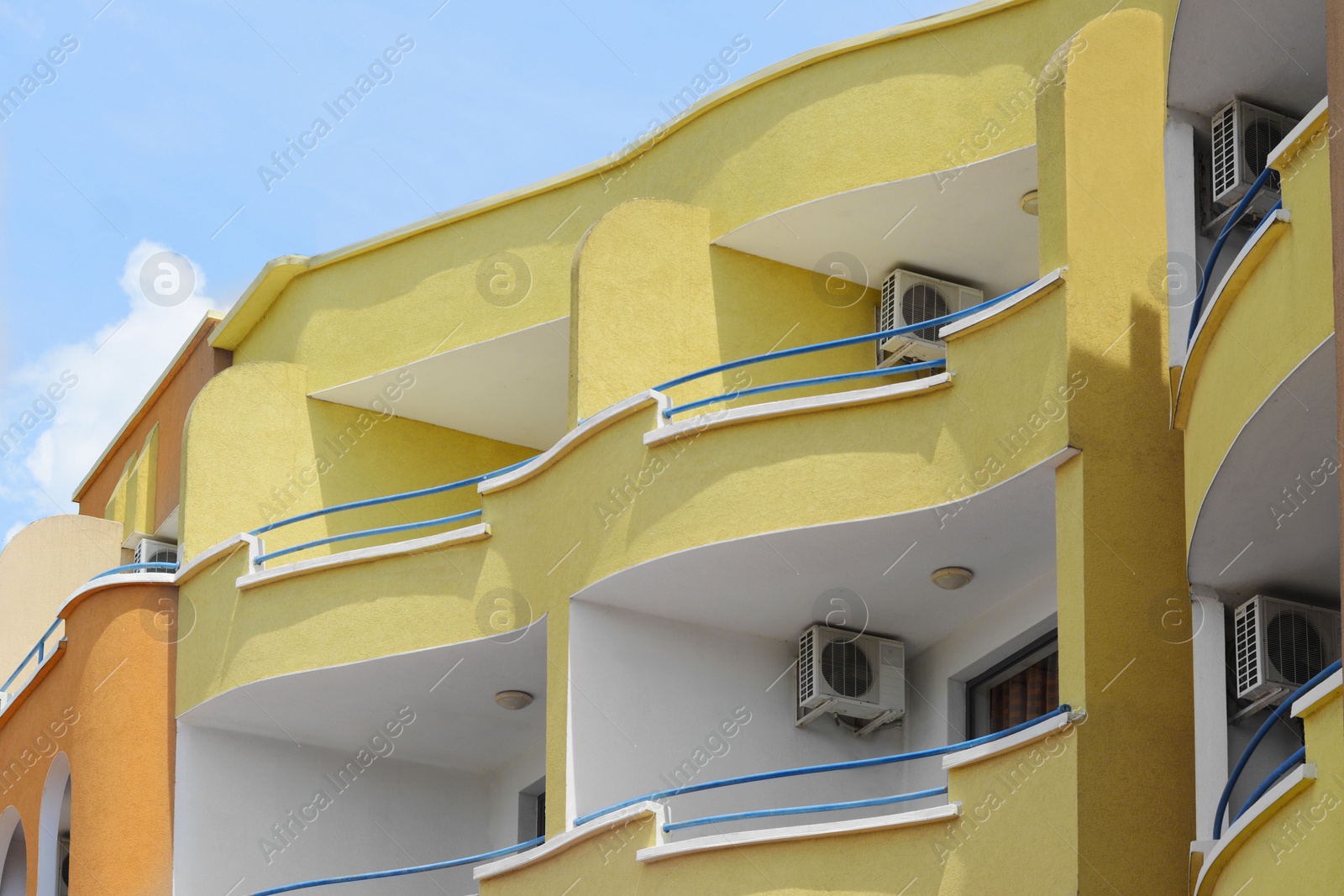 Photo of Exterior of residential building with balconies against blue sky