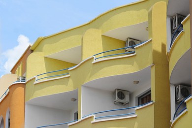 Exterior of residential building with balconies against blue sky