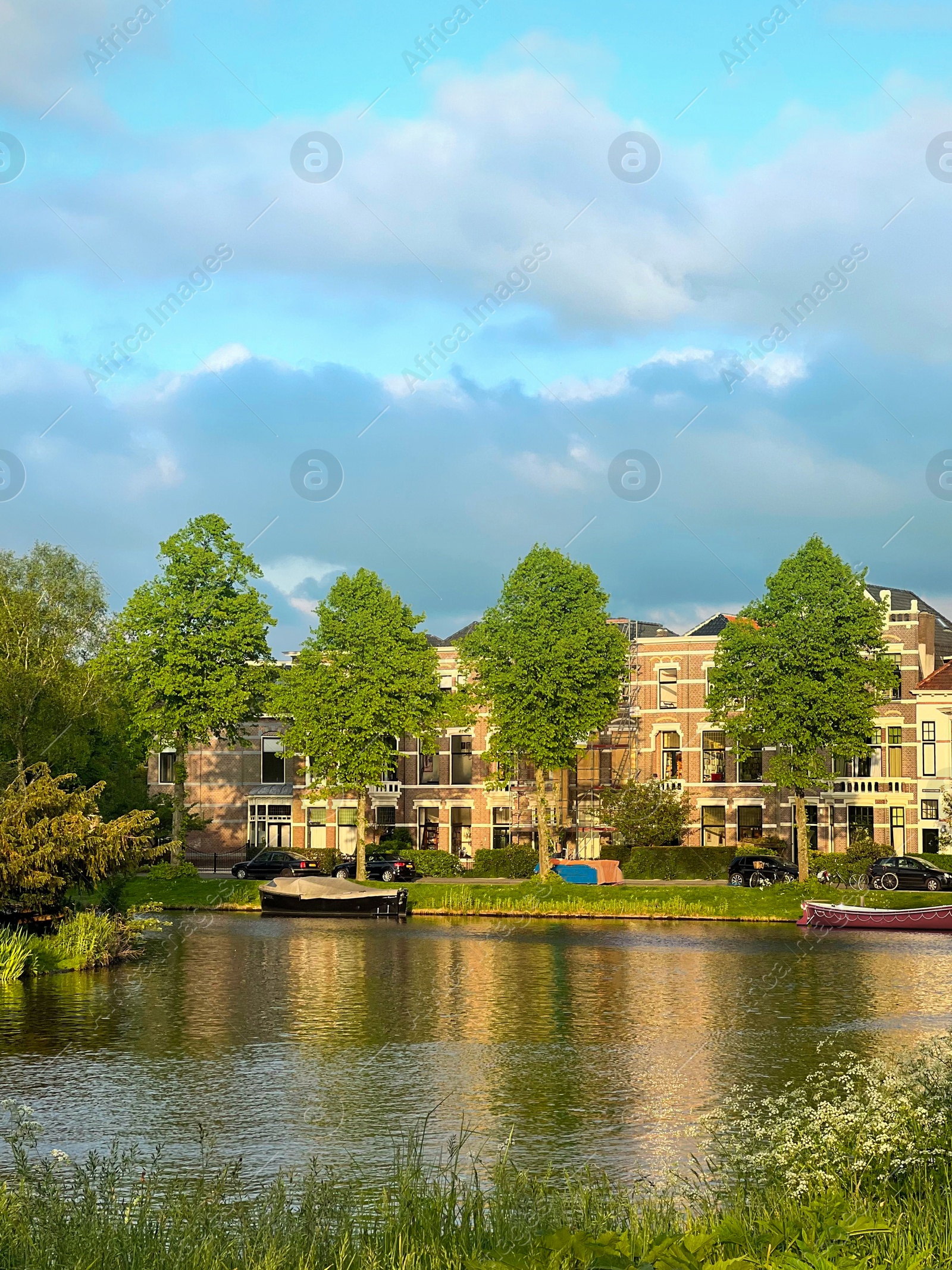 Photo of Picturesque view of city canal with moored boats and beautiful building