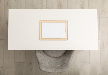 White table with photo frame near chair indoors, top view